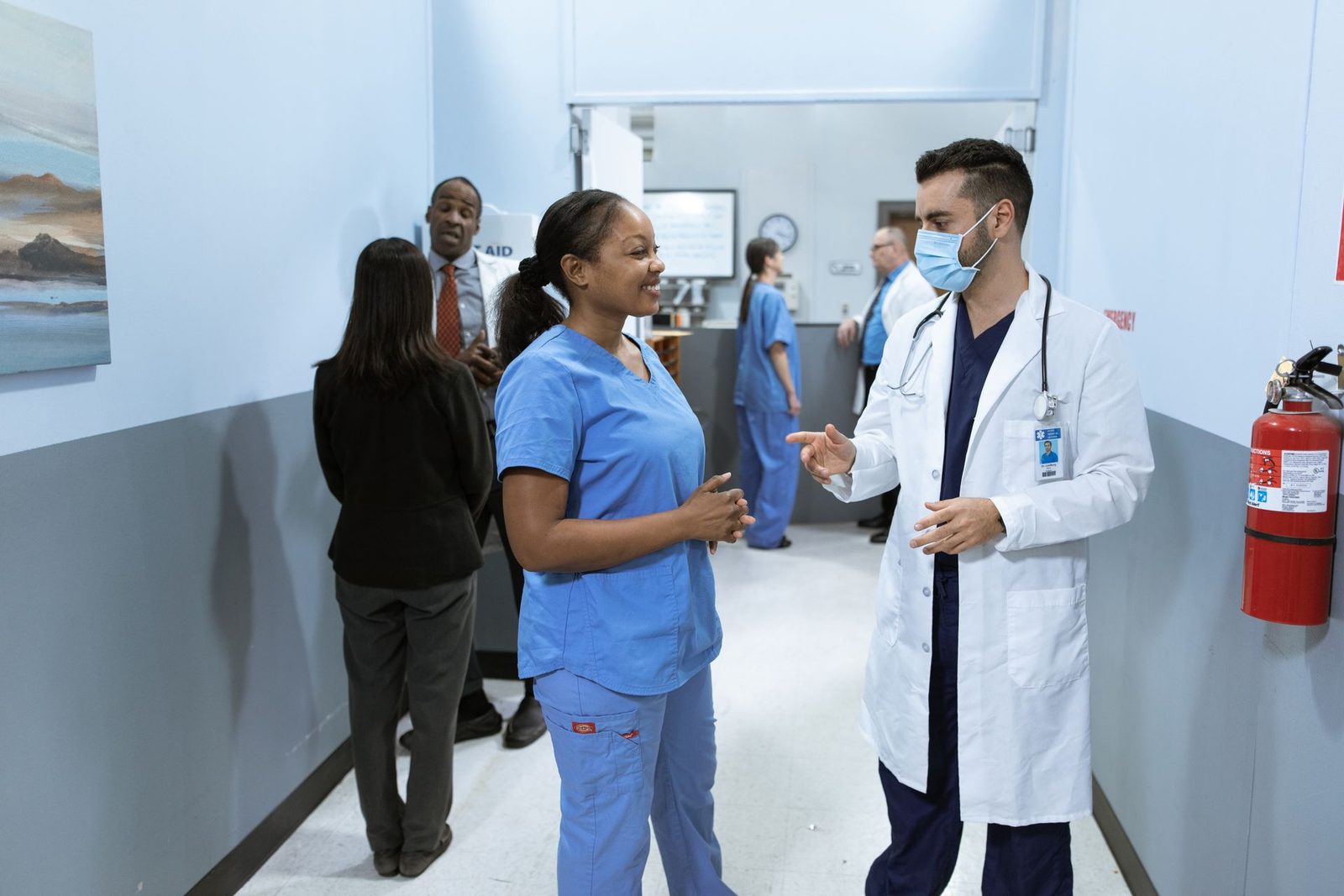 Profissionais de saúde conversando em corredor de hospital