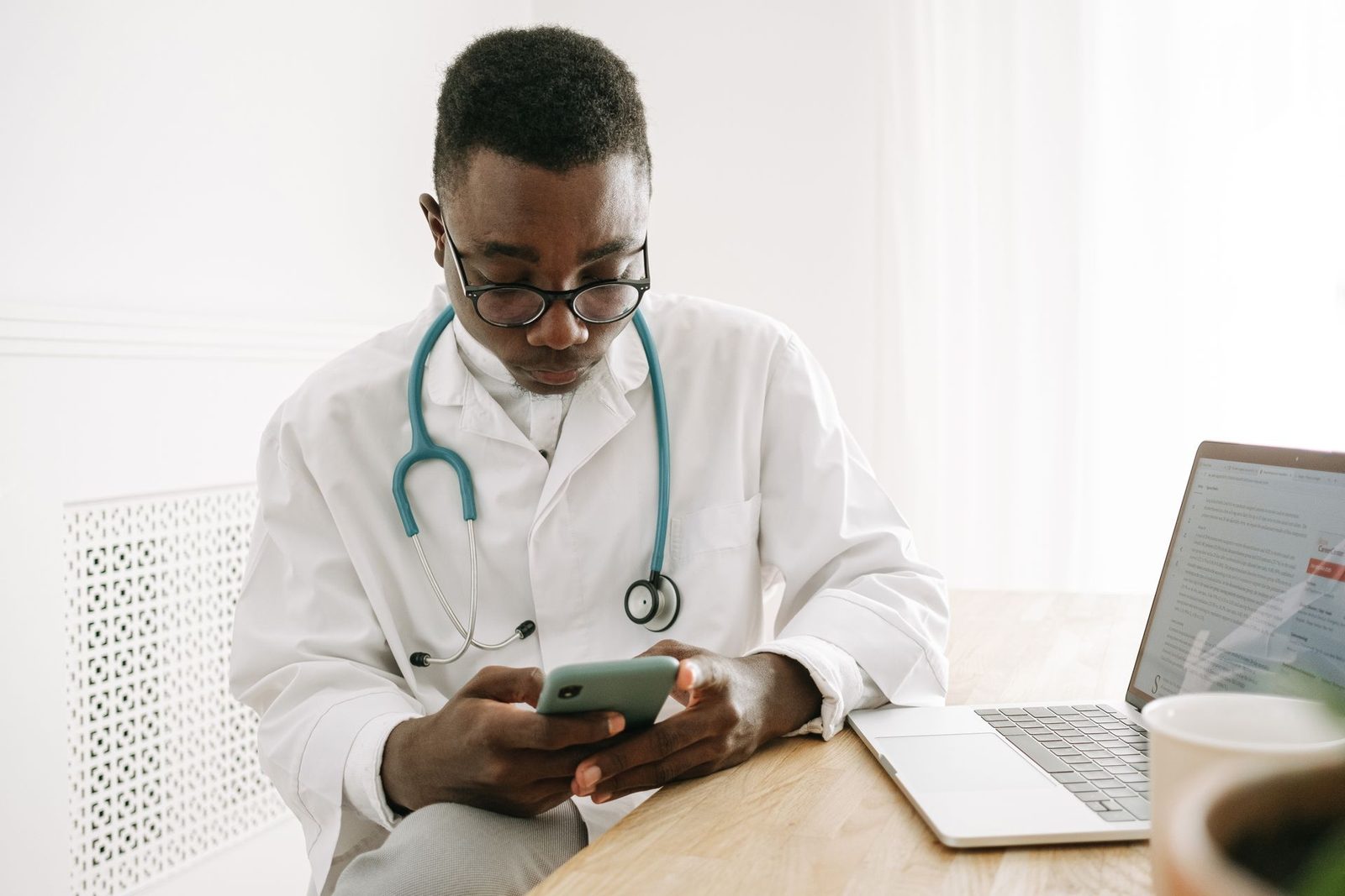 Médico consultando o celular no consultório
